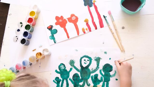 Child girl painting friendly funny aliens, Creative activities with a child to develop creative imagination, have a fun time
