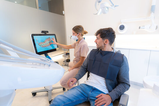 Dentist using modern technology to explain procedure to a man