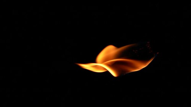 Vertical closeup torch fire flame burning over black background in slow motion