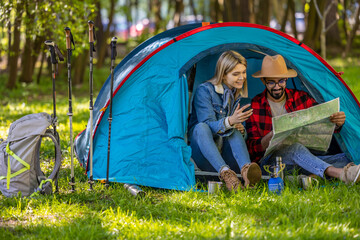 Young couple of travelers in the tent feeling relaxed