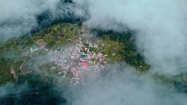 Drone pans left to right, revealing Tapay village lost amidst clouds. Breathtaking Andean scenery