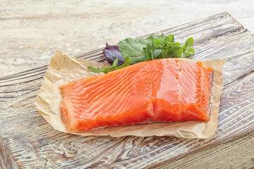 Raw salmon fillet over board