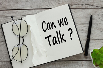 a notebook with glasses on it. words CAN WE TALK?