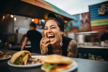 Foto op Aluminium Beautiful young woman eating a hamburger in a fast food restaurant. © Nerea