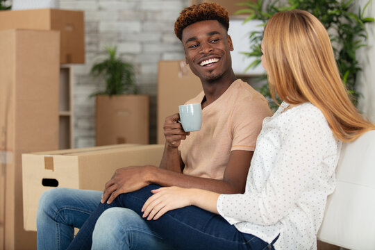 happy couple with boxes drinking coffee - Powered by Adobe