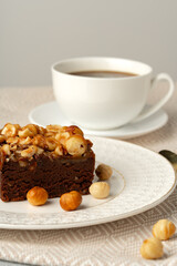 Brownie cake with nuts topping on plate close up
