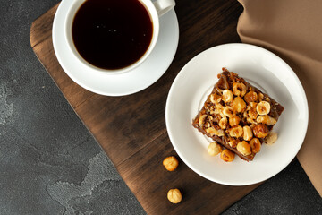 Brownie cake with nuts topping on plate close up