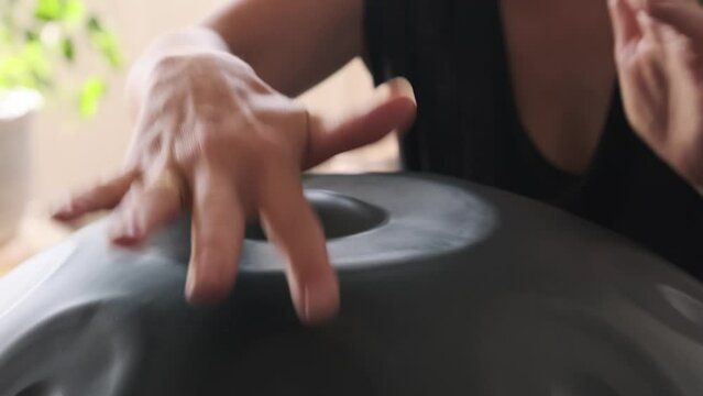 a woman plays on handpan or hang