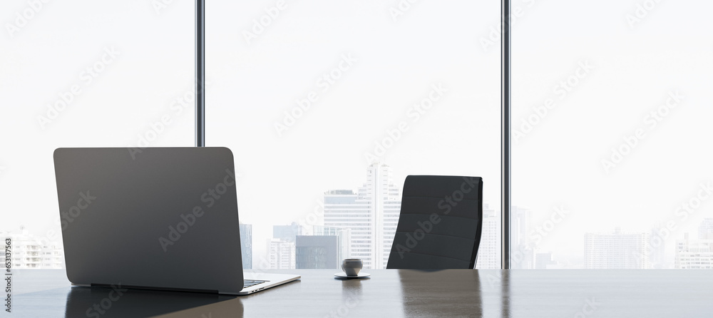 Poster Close up of new backlit workplace with laptop, table lamp, coffee cup and panoramic window with city view in the background. 3D Rendering.
