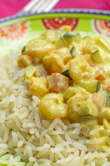 assiette de crevettes au curry et lait de coco accompagné de riz blanc, en gros plan	