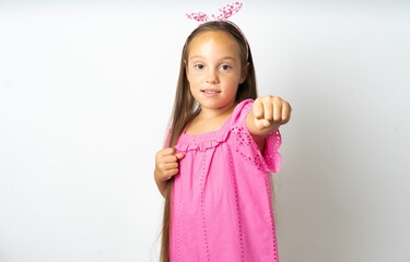 beautiful kid girl wearing pink dress  Punching fist to fight, aggressive and angry attack, threat and violence