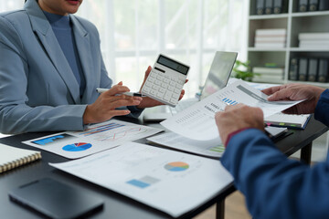 team work process Business team use calculator to calculate figures, business statistics, profit, cost analysis, growth rate graph document. data charts on the desk