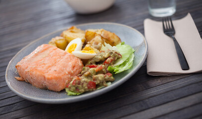 Steamed salmon fillet with potato wedges, guacamole homemade and quail egg