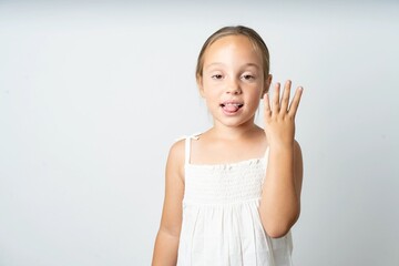 beautiful kid girl wearing white dress smiling and looking friendly, showing number four or fourth...