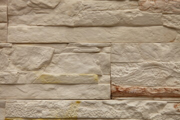The background of the wall is made of modern white brick with red and yellow inclusions. Close-up.
