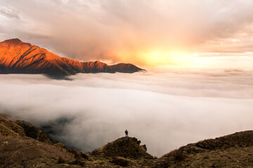 a sea of cloud rolling into the himalayas, nepal at sunset