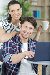 portrait of cheerful couple using laptop together