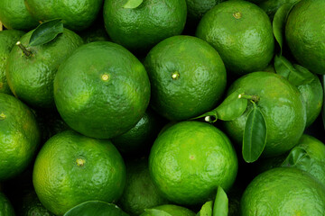 Background of Asian green oranges with leaves