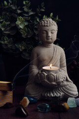 stone statue of buddha with a candle