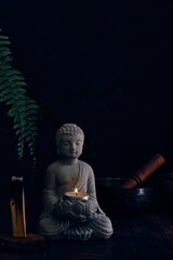 stone statue of buddha with a candle