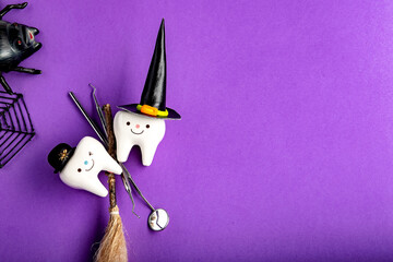 dental concept. tooth figurine in halloween costume and dental tools. pumpkins and a broom.on a...