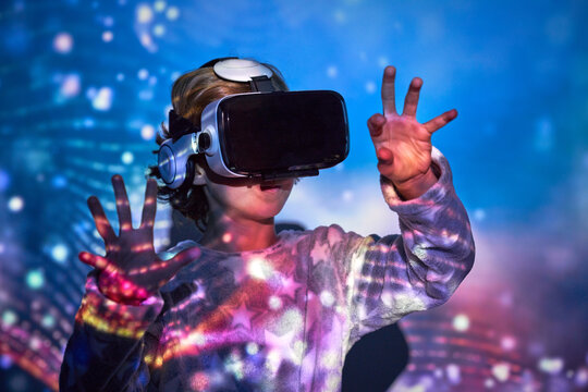 Attentive kid touching imaginary objects in VR headset