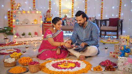 Diwali preparation - An Indian man and his wife doing Diwali decorations  Hindu festival  floral...