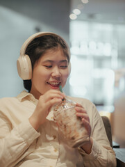Asian teen girl using tablet watching online multimedia in coffee shop