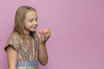 Happy kid girl with tasty pink donut on bright pink banner background