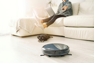 Person switching robotic vacuum cleaner in living room
