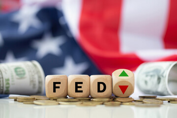 The Federal Reserve ( FED ) to control interest rates. Wooden blocks FED on coins with USA flag background. American economy and business. Federal Reserve Bank Interest rates rise policy. FED concept. - obrazy, fototapety, plakaty