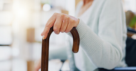 Hand, walking stick and closeup for woman in nursing home, living room or hospital for mobility...
