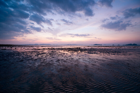 An image of a beach as the sunset in Thailand. The vastness of the beach is emphasized using a wide angled lens.
