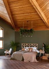 Luxurious master bedroom in modern style with big window in the log house. Wooden bed and attic ceiling. - 653171322