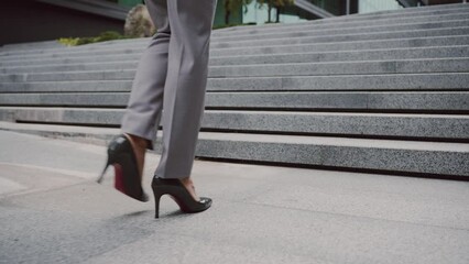 Businesswoman in high heels walking stairs outdoors