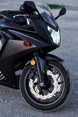 Black colored vehicle. Close up view of modern motorcycle that is parked outdoors