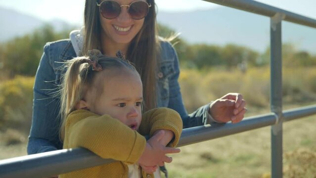 Girl and woman looking through gate - Close Up