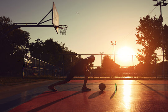 Man with basketball ball on a public court.