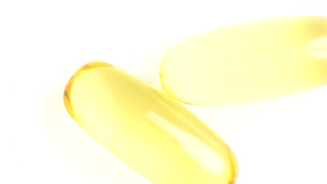 Food supplement oil filled. Capsules with omega 3 or vitamin A, E, fish oil. Macro shot, slow motion, top view. Pills background, capsules texture