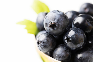 Close up of Blueberries fruit with leaves on white background