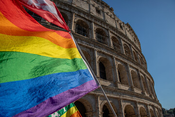 The colored flag of peace under the Colosseum in Rome at the pride.