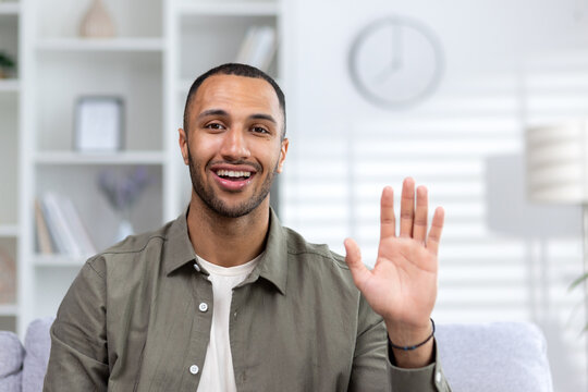 Portrait Of A Young African American Male Teacher. A Business Coach Who Greets And Talks Via Video Link To The Camera From Home