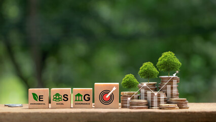 ESG. Environmental, social and governance. Green business growth. Words ESG  on a woodblock with goal icon and  tree growing on money coin stack. Finance sustainable development. Green finance.