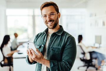 Young designer using a mobile phone in an office