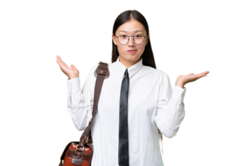 Young Asian business woman over isolated background having doubts while raising hands
