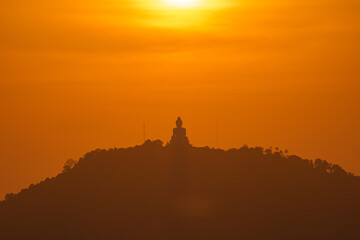 scenery yellow sky glare of sun above Phuket big Buddha.Phuket Big Buddha is one of the island most important and revered landmarks on the island..image for travel and culture concept. © Narong Niemhom