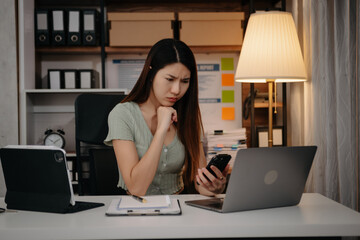 Woman who is tired and overthinking from working with tablet and laptop at modern office..