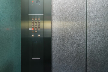 Control panel in modern passenger elevator. It consists of choose-floor and open/close-door buttons.