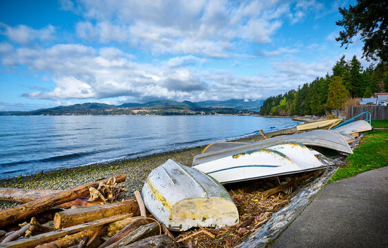 Driftwood and old boats on Davis Bay Beach. Sechelt, Sunshine Coast, British Columbia, Canada. Beautiful Pacific Coast of Canada