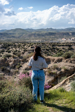 Young woman looking at Tabernas desert on a sunny day, Almeria, Andalusia
